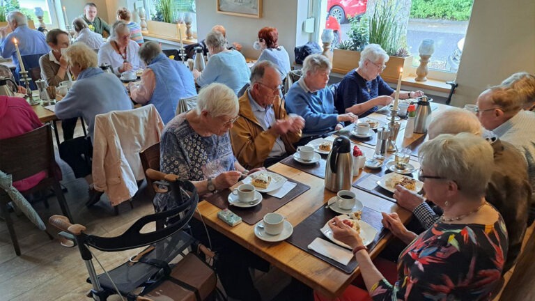Die Teilnehmenden genießen gemeinsam Kaffee und Kuchen.